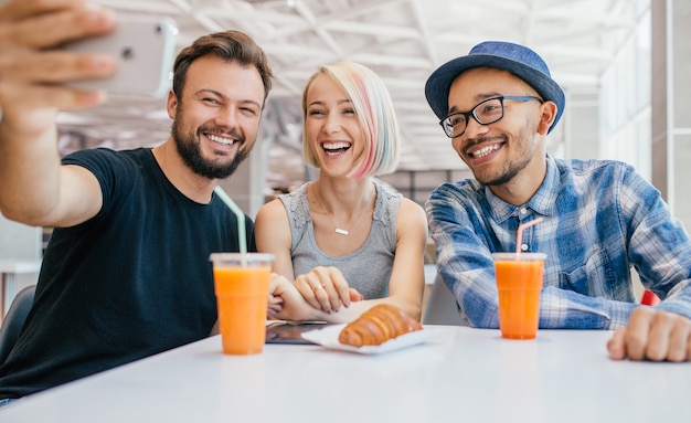 Happy multiethnic young friends at cafe