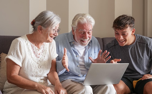 Happy multigenerational family of grandparents and young grandson in video call by laptop
