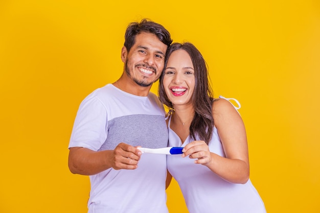 Happy multinational couple celebrating positive pregnancy test result Happy and affectionate joyful couple celebrating motherhood