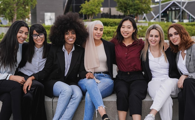 Photo happy multiracial business women smiling on camera during lunch break outside of office