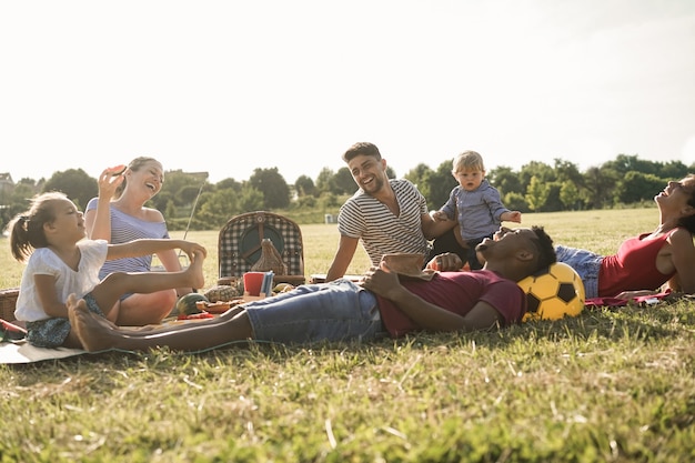 写真 夏休みの間に都市公園で屋外でピクニックをしている幸せな多民族の家族-主な焦点の子供の男の子