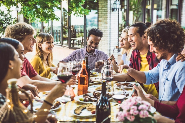 야외에서 바베큐 저녁 파티를 하는 행복한 다인종 가족