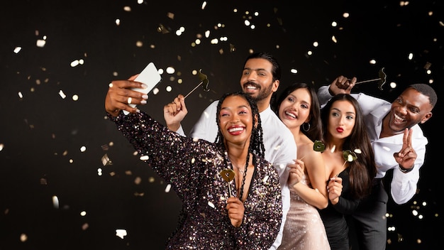 happy multiracial friends cleebrating new year together taking selfie