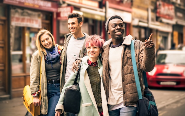 Happy multiracial friends walking on Brick Lane at Shoreditch London