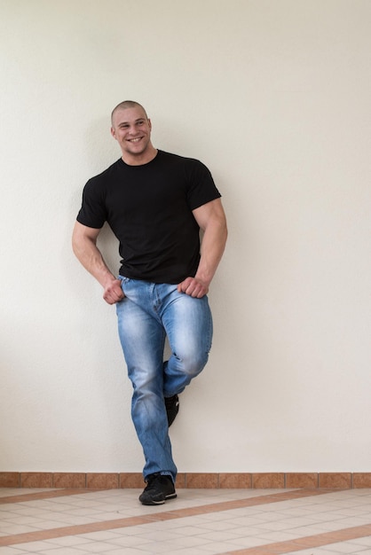 Happy Muscular Man In Black TShirt Standing And Showing His Muscle