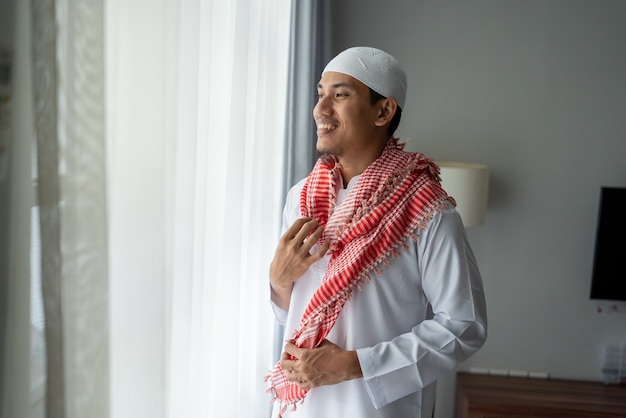 Premium Photo  An arab man, a businessman, a sheikh stands in front of a  skyscraper window. investments, business, work via the internet, online  contracts.