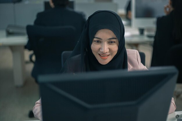 Happy muslim asian woman working and using pc at office meeting