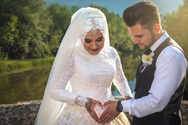 幸せなイスラム教徒のカップルは彼らの新婚旅行のイスラム教徒の結婚式の日を楽しんでいます