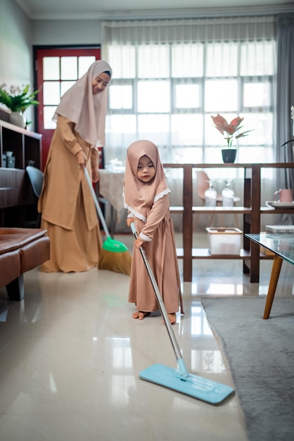 Happy muslim family cleans the room together