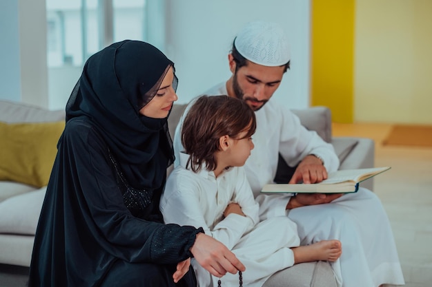 Photo happy muslim family enjoying the holy month of ramadan while praying and reading the quran together in a modern home.