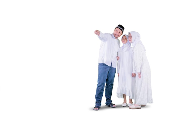 Happy Muslim family pointing copy space on studio