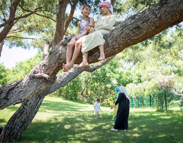 Счастливая семья мусульман в парке деревьев