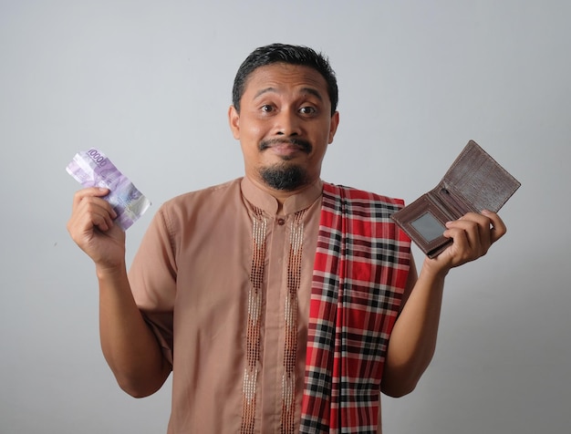 Happy muslim man carrying wallet and indonesian money