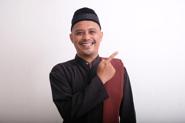 Photo happy muslim man pointing finger to the side