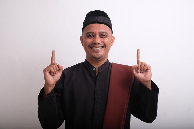 Photo happy muslim man pointing finger to the top