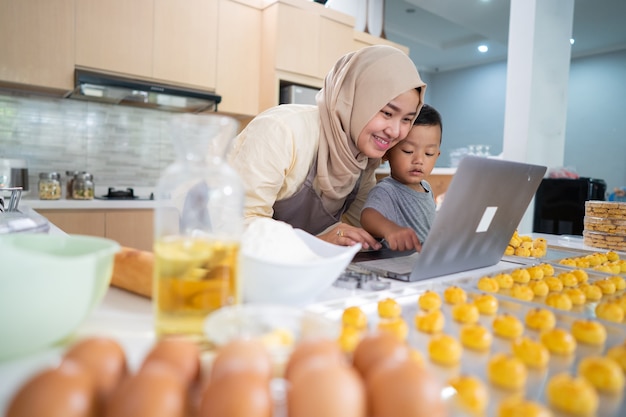 Happy muslim mother working from home making food order of nastar pineapple cake for eid mubarak kar