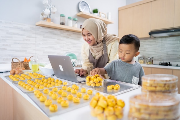 Happy muslim mother working from home making food order of nastar pineapple cake