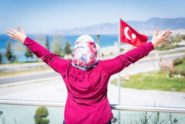 写真 彼女の後ろにトルコの旗があるホテルパークのハッピーイスラム女性