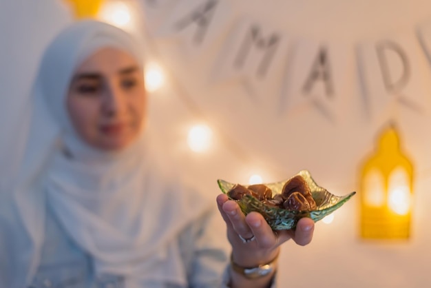 A happy Muslim woman eating dates for iftar to break fast during the Ramadan eid Mubarak Ramadan