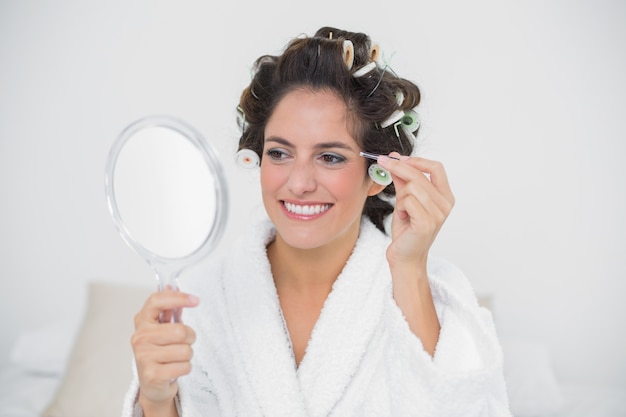 Happy natural brunette using tweezers