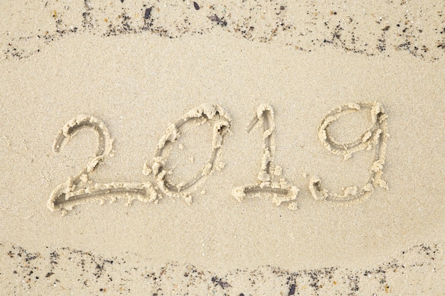 Happy new year.2019 handwritten on sandy beach