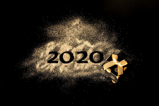 Foto felice anno nuovo 2020. collage creativo di numeri due e zero costituiva l'anno 2020. bellissimo scintillante numero d'oro 2020 su nero