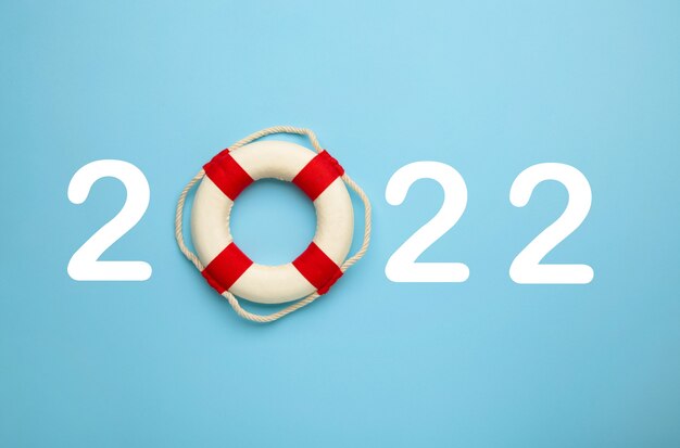 Happy new year 2022. Happiness and travel summer destination concept. Number 2022 with lifebuoy on blue