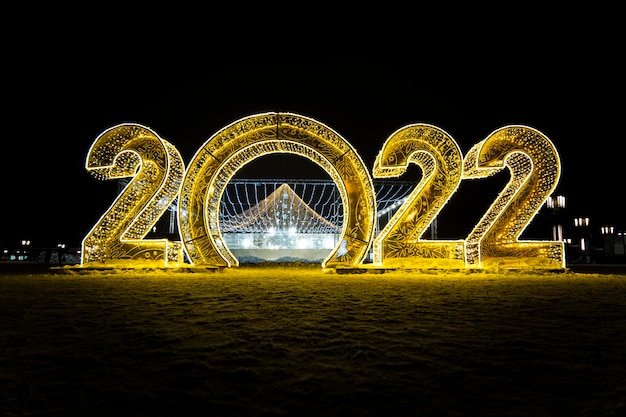 Happy New Year 2022 Sparkling burning numbers Year 2022 with on black background christmas street