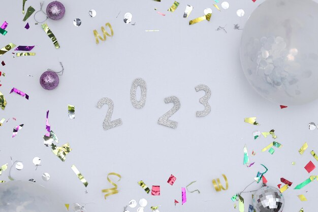 Happy New Year 2023. Silver numbers with falling confetti particles. Festive sparkling ornament