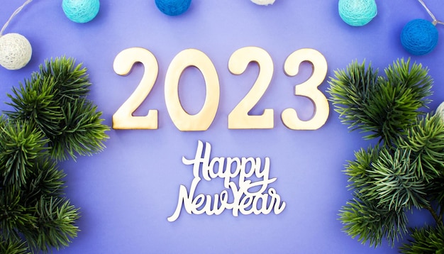 Happy New Year 2023 A symbol from the number 2023 with Golden balls stars sequins and a beautiful bokeh The concept of the celebration