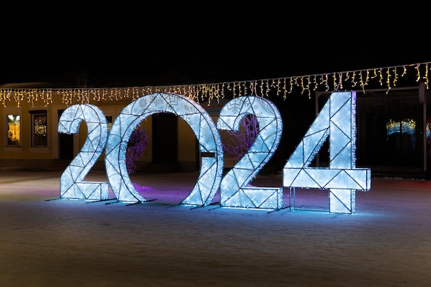 Happy New Year 2024 Sparkling burning numbers Year 2022 with on black background christmas street decorations Beautiful design element