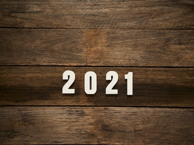 Happy New Year background with 2021 figures on rustic dark wooden background. Space for text