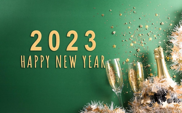 Happy New year celebration background concept Champagne with glass golden ribbon stars and christmas ball on green background