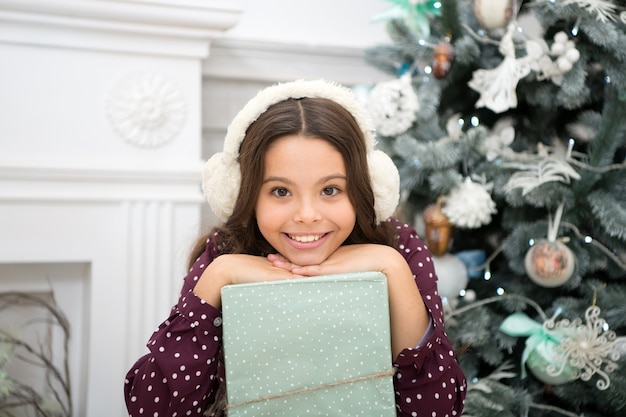 Buon anno. natale. ragazzo, goditi la vacanza. piccola ragazza felice a natale. la mattina prima di natale. vacanze di capodanno. alla bambina piace il regalo di natale. festa di natale. natale sta arrivando.