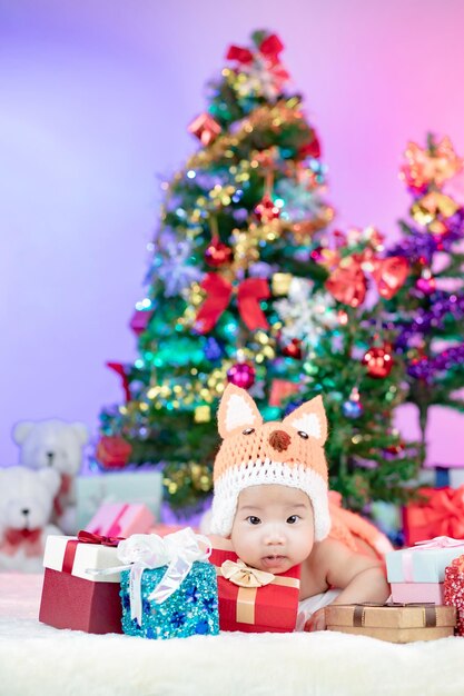 Happy new year christmas tree with cute little baby wearing fox costume crochet knitted