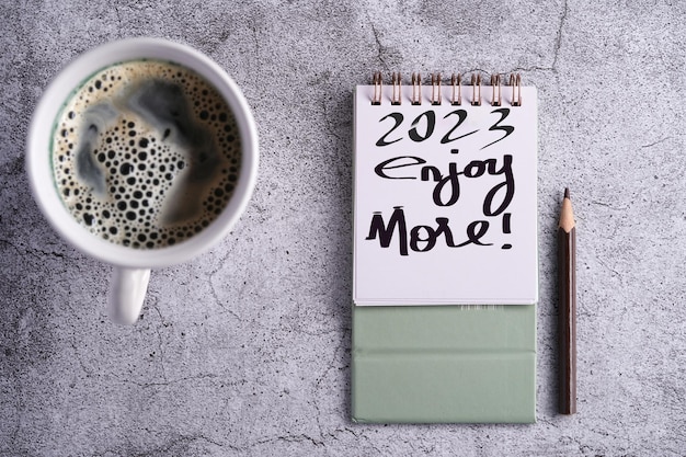 Happy new year desktop calendar 2023 and cup of coffee on
cement background