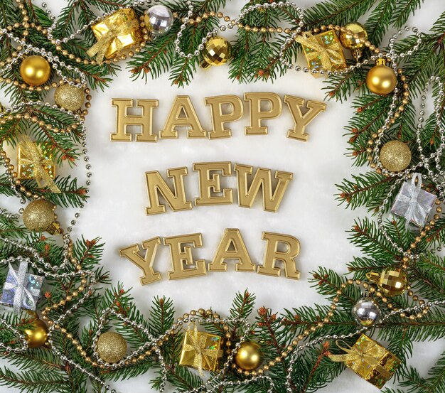 Happy New Year golden text and spruce branch and Christmas decorations on a white background