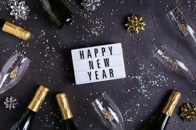 Happy New Year greeting card champagne glasses and bottles confetti