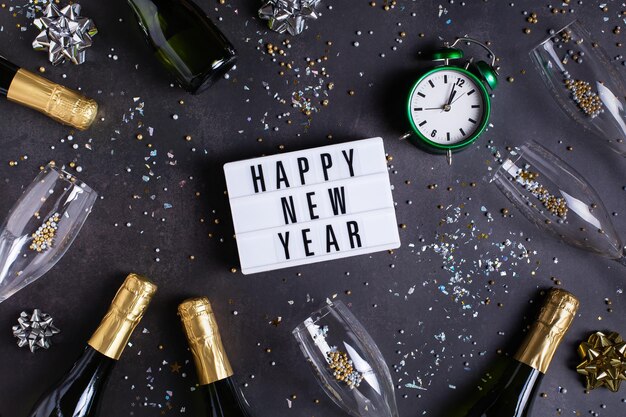 Happy New Year greeting card champagne glasses and bottles confetti