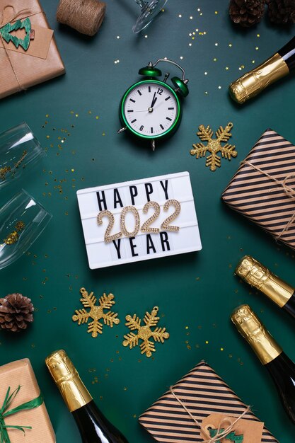 Foto biglietto di auguri di felice anno nuovo con champagne e scatole regalo