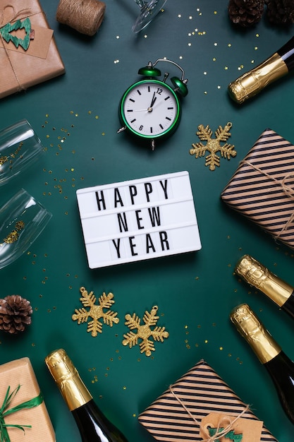 Foto biglietto di auguri di felice anno nuovo con champagne e scatole regalo