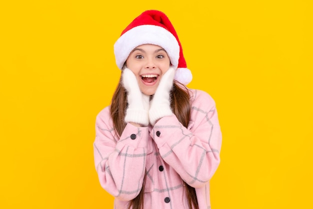 Happy new year merry christmas amazed kid in santa claus hat teen girl in mittens