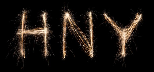 Happy New Year Sparkler Light drawn in letters at night time to celebrate special holiday 