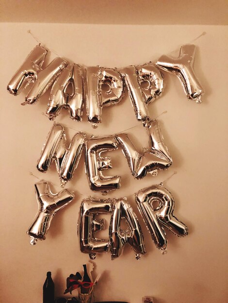 Happy new year text hanging against wall