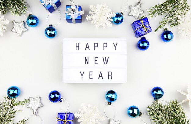 HAPPY NEW YEAR text on lightbox composition and of Christmas decorations 