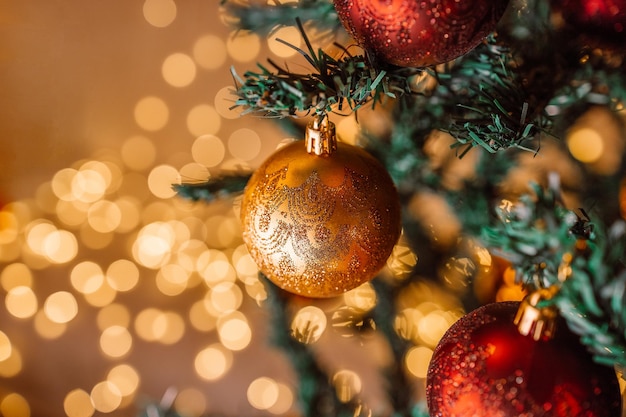 Tema di felice anno nuovo con decorazioni di palline rosse e oro natalizie sul ramo di un albero di natale sopra il bellissimo...