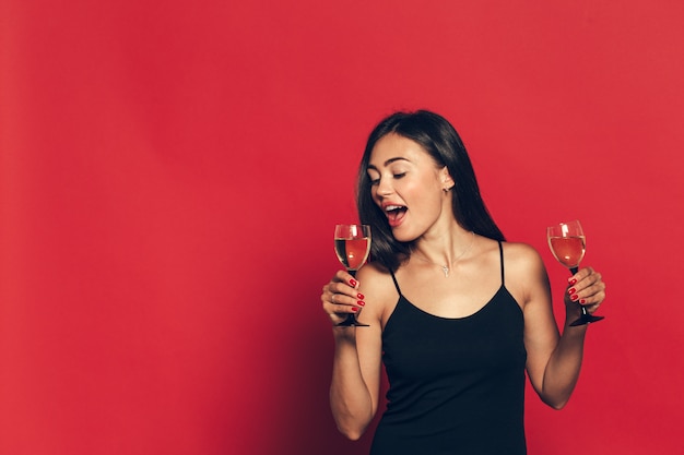 Buon anno a te. una donna giovane e bella che balla con un bicchiere di champagne