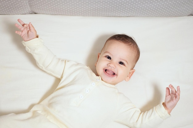 Happy newborn baby makes a funny face Portrait of a crawling baby in his room close up