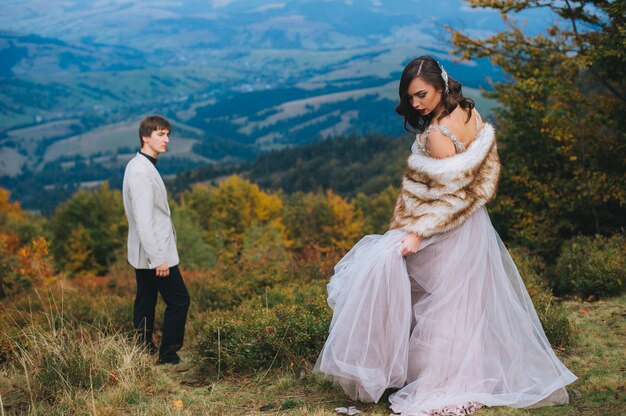 happy newly married couple posing in the mountains