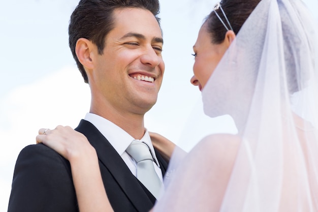 Happy newly wed couple against sky